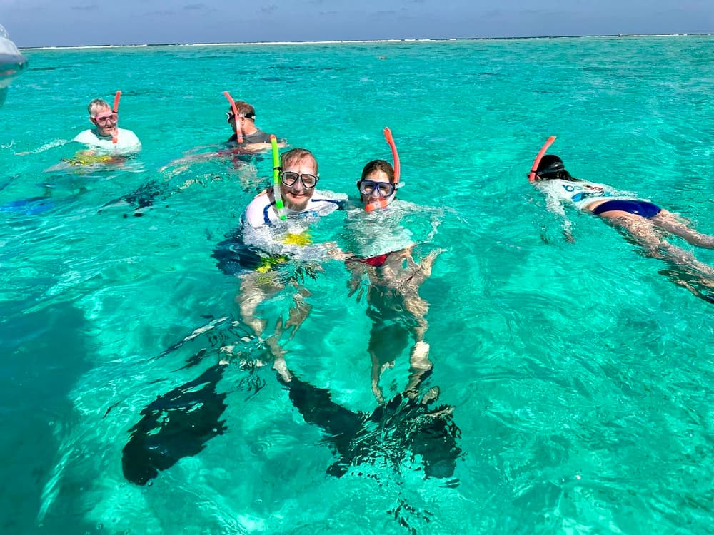 A group of people snorkeling in clear turquoise water.