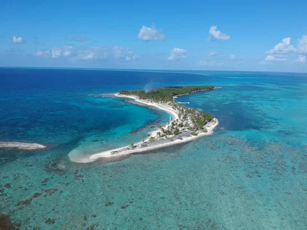 Aerial view of a tropical island surrounded by turquoise waters.